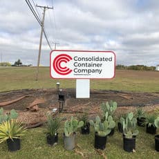Signage for Consolidated Container Company with potted plants in foreground.